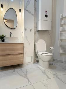 La salle de bains est pourvue de toilettes, d'un lavabo et d'un miroir. dans l'établissement Sunshine Getaway - Stylish Studio in the Heart of Nice, à Nice