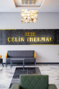 a lobby with a couch and a sign on the wall at Çelik Thermal & Spa in Pamukkale