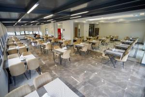 a dining room filled with tables and chairs at Çelik Thermal & Spa in Pamukkale +42 photos