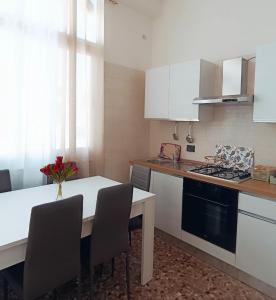 塔蘭托的住宿－Dimora degli Arcangeli，厨房配有白色的桌椅和炉灶。