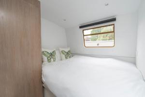 Serenity in the Heart of London في لندن: غرفة نوم صغيرة بها سرير ونافذة