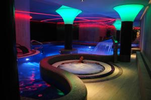 a man in a hot tub in a room with lights at Hotel Jakuszyce Sport & Spa in Szklarska Poręba