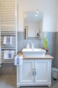 bagno con lavandino bianco e specchio di Ferienhaus Kranich a Pruchten