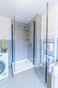 a bathroom with a shower and a washing machine at Ferienhaus Kranich in Pruchten
