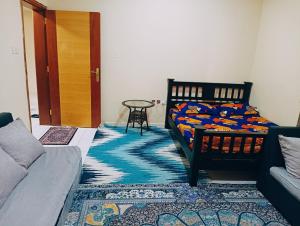 a bedroom with a bed and a table and a rug at Place where stay for good time in Ajman 