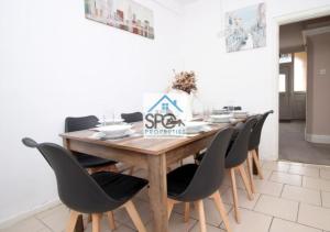 a dining room with a wooden table and chairs at Spacious 4BR Home-8 Guests-Business-Families-Netflix-Free Parking & WiFi in Cardiff