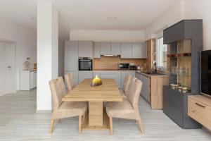 a kitchen with a wooden dining table and chairs at Apartma Žan in Šmarje