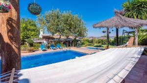 a hammock by a swimming pool in a resort at Villa Munoz Ronda by Ruralidays in Ronda