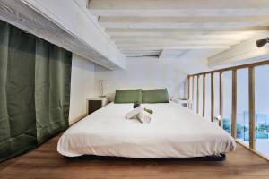 ein Schlafzimmer mit einem weißen Bett mit einem Teddybär darauf in der Unterkunft Le cocon de Saint-Clair in Caluire-et-Cuire