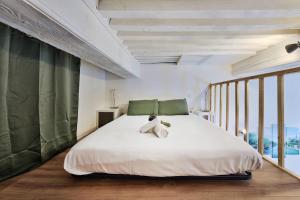 a bedroom with a white bed with a teddy bear on it at Le cocon de Saint-Clair in Caluire-et-Cuire