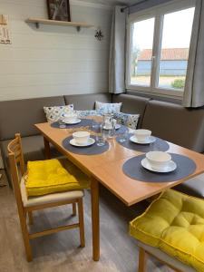 La Boissière-de-Montaigu的住宿－Mobil Home cosy 5 personnes proche du Puy Du Fou，一间带木桌和椅子的用餐室