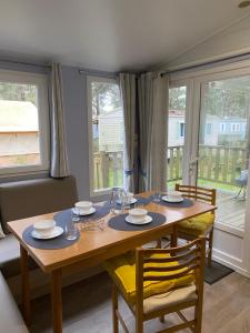 - une salle à manger avec une table et des chaises en bois dans l'établissement Mobil Home cosy 5 personnes proche du Puy Du Fou, à La Boissière-de-Montaigu