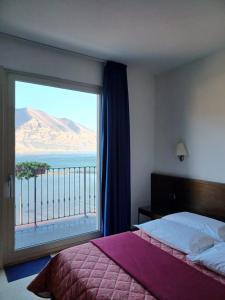 una camera da letto con una grande finestra con vista sull'oceano di Locanda del Lago Rosmunda a Clusane sul Lago