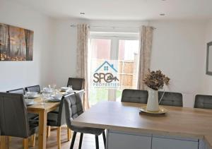 uma sala de jantar com uma mesa de madeira e cadeiras em Modern 3BR Home-6 Guests-Business-Families-Netflix-Free Parking & WiFi em Pontnewydd