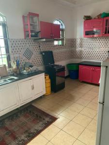 een keuken met rode kasten en een zwart aanrecht bij Good Vibes Stay in Dar es Salaam