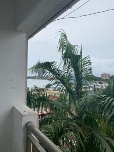 een balkon met uitzicht op een palmboom bij Good Vibes Stay in Dar es Salaam