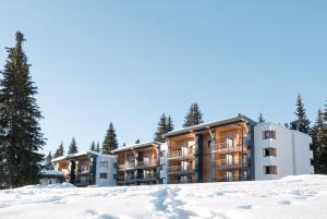 un edificio de apartamentos con árboles en la nieve en Belambra Clubs Les Saisies - Les Embrunes - Ski pass included, en Villard-sur-Doron