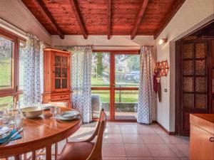 een eetkamer met een tafel en een groot raam bij Casa Lucia in Claino