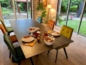 una mesa con platos y tazones de comida. en Domaine de Montloue - Relais Bien-être, en Mellac