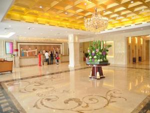 a lobby with a chandelier and flowers on a table at Chang An Hotel in Shenzhen