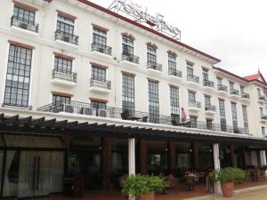ein großes weißes Gebäude mit Balkonen und Tischen in der Unterkunft Pontefino Hotel and Residences in Dilao