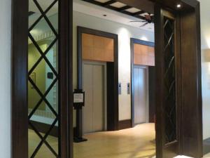 un couloir avec deux portes en verre dans un bâtiment dans l'établissement Pontefino Hotel and Residences, à Dilao