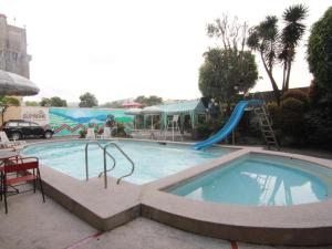 a large swimming pool with a slide in the middle at Hotel Supreme in Baguio +92 photos