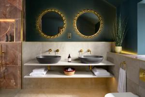 two sinks in a bathroom with two mirrors at Charlton Hall at Charlton Hall Estate in North Charlton