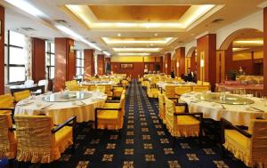 西安市にあるXian Empress Hotelのテーブルと椅子のあるレストラン