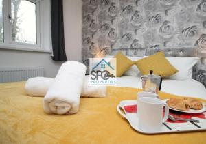 Habitación de hotel con cama y bandeja de comida en Cosy 2BR Home-4 Guests-Business-Families-Netflix-Free Parking & WiFi en Caerleon