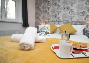 a hotel room with a bed with a tray of food at Cosy 2BR Home-4 Guests-Business-Families-Netflix-Free Parking & WiFi in Caerleon