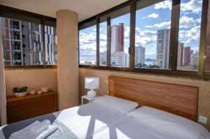 a bedroom with a bed with a view of a city at SOL 7 Levante Beach in Benidorm