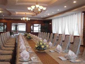 Długa jadalnia z długim stołem i krzesłami w obiekcie HAGL Hotel Gia Lai w mieście Pleiku