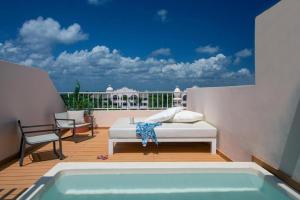 einen Balkon mit einem Bett und einem Pool in der Unterkunft Excellence Riviera Cancun All Inclusive - Adults Only in Puerto Morelos