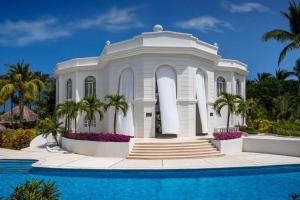 ein weißes Haus mit einem Pool davor in der Unterkunft Excellence Riviera Cancun All Inclusive - Adults Only in Puerto Morelos