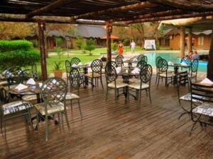 een patio met tafels en stoelen en een zwembad bij Chrismar Hotel in Riverside