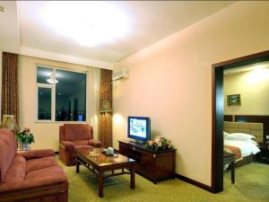 a living room with a couch and a room with a bed at Beijing Hepingli Hotel in Beijing