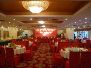 a banquet hall with white tables and red chairs at Shanshui Hotel in Xiamen +158 photos