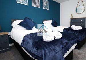 two beds in a bedroom with blue walls at Modern 3BR Home-5 Guests-Business-Families-Netflix-Free Parking & WiFi in Cefn-coed-y-cymmer