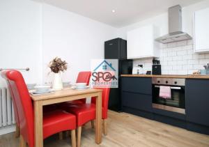 a kitchen with a wooden table and red chairs at Modern 3BR Home-5 Guests-Business-Families-Netflix-Free Parking & WiFi in Cefn-coed-y-cymmer