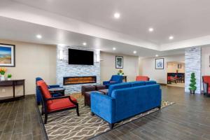 sala de estar con sofás azules y chimenea en Comfort Suites en Copperas Cove