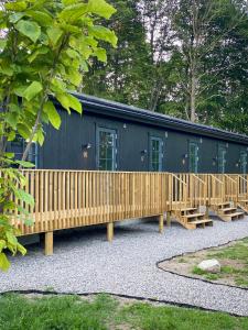 ein schwarzes Gebäude mit einem Holzzaun und Bänken in der Unterkunft Rallarhustruns in Hässleholm