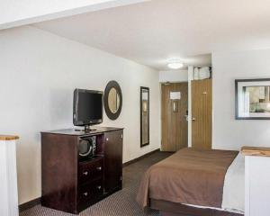 a hotel room with a bed and a flat screen tv at Quality Inn & Suites in Sturgeon Bay