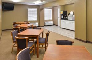 une salle à manger avec des tables et des chaises ainsi qu'une cuisine dans l'établissement Americas Best Value Inn Smackover, 