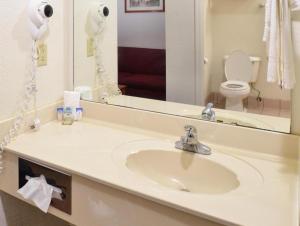 uma casa de banho com um lavatório e um espelho em Americas Best Value Inn Smackover 