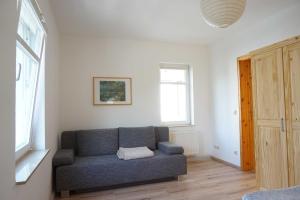 una sala de estar con un sofá azul en una habitación en "Villa Rügen" - 300 m zum Strand, en Binz