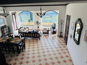 uma sala de estar com um sofá, uma mesa e cadeiras em Villas Lugrezia Sea View em Méson Yerakaríon