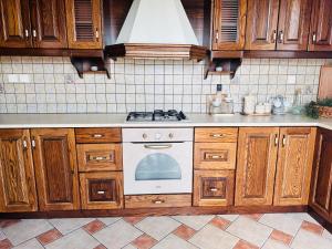 een keuken met houten kasten en een kookplaat met oven bij Villas Lugrezia Sea View in Méson Yerakaríon