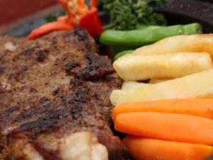 a plate of food with meat and vegetables and broccoli at Riyadi Palace Hotel in Solo