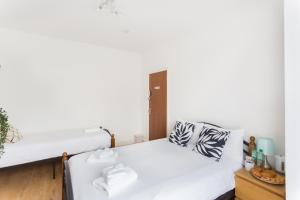 a bedroom with two beds and a table at Wood Green Budget Rooms - Next to Mall & Metro Station - 10 Min to City Center in London